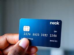 Hand holding a credit card, symbolizing building credit score.